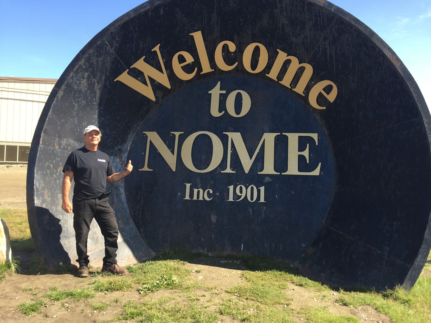 Founder of America's Auction Channel at Welcome to Nome Alaska sign.